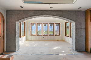 Unfurnished room featuring arched walkways