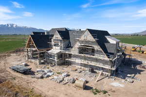 Rear view of property with a shingled roof, a rural view, a mountain view, and a chimney