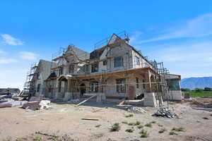 Rear view of property featuring stone siding and a mountain view
