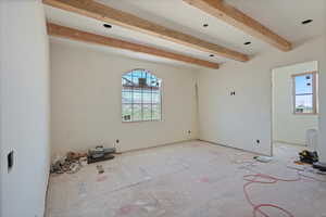 Empty room with beamed ceiling
