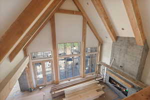 Unfurnished living room with a warm lit fireplace and french doors