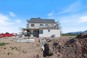 Back of house with central AC unit, stucco siding, and a balcony