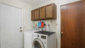 Laundry room featuring cabinet space and washer and clothes dryer