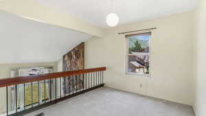 Hallway with carpet, lofted ceiling, and baseboards