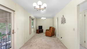 Sitting room featuring a chandelier and light carpet