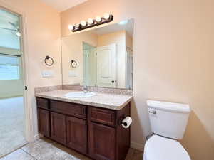 Bathroom with vanity, toilet, tile patterned flooring, and baseboards