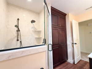 Bathroom with a stall shower and wood finished floors