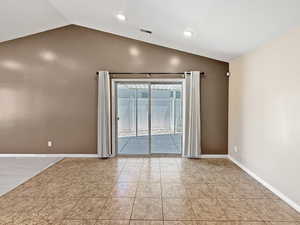 Empty room with lofted ceiling, baseboards, light tile patterned floors, and recessed lighting
