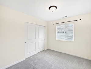Unfurnished bedroom with carpet floors, a closet, and baseboards