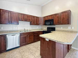 Kitchen featuring black appliances, a sink, light countertops, a peninsula, and light tile patterned flooring