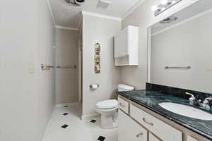 Full bathroom featuring vanity, a shower stall, toilet, baseboards, and a textured ceiling