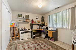 Office featuring light tile patterned flooring and a textured ceiling
