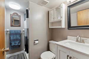 Full bathroom featuring wood finished floors, vanity, and toilet