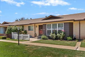 Ranch-style house with roof with shingles, brick siding, and covered porch