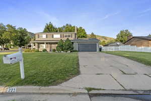 View of front of property with concrete driveway, an attached garage, and a mountain view