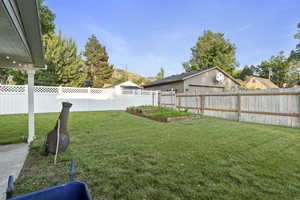 View of yard with a vegetable garden and a garage