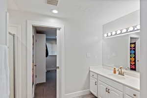 Primary Full bath featuring vanity, baseboards, an enclosed shower, and a textured ceiling
