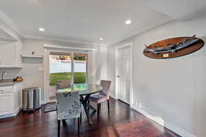 Dining space featuring dark wood-style floors, baseboards, recessed lighting, and crown molding