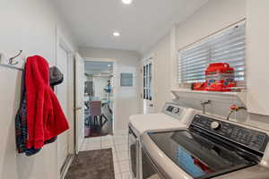 Laundry area with washer and dryer, light tile patterned floors, recessed lighting, electric panel, and crown molding