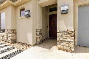 Entrance to property featuring stone siding and stucco siding
