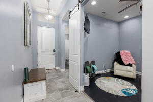Entryway with a barn door, a ceiling fan, baseboards, and recessed lighting
