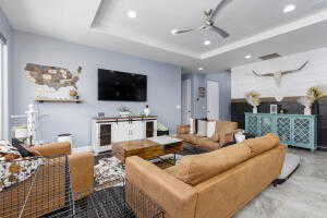 Living area featuring recessed lighting, a ceiling fan, and a raised ceiling