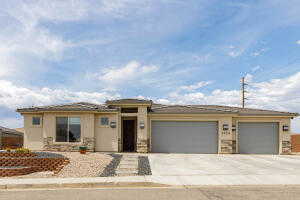 Prairie-style home featuring a garage, concrete driveway, and stucco siding
