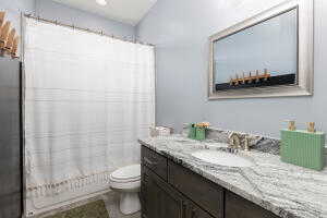 Full bath with vanity, toilet, and shower / tub combo with curtain
