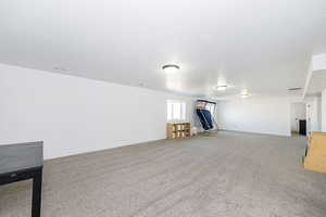 Basement featuring light carpet and baseboards