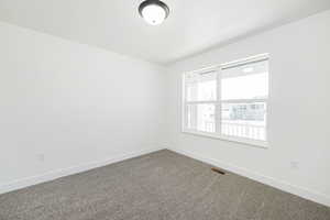 Carpeted spare room with baseboards