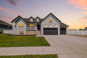 Modern inspired farmhouse featuring board and batten siding, concrete driveway, covered porch, and a garage