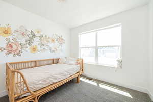 Bedroom featuring carpet and baseboards
