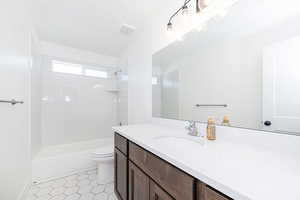 Bathroom featuring vanity,  shower combination, and toilet