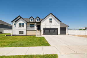 Modern farmhouse style home with board and batten siding, a porch, driveway, and a garage