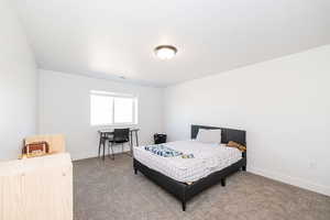 Bedroom featuring carpet flooring, baseboards, and a desk