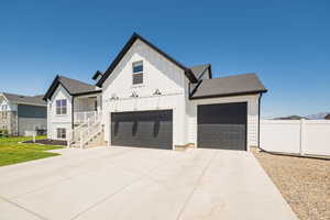 Modern farmhouse style home featuring board and batten siding, driveway, a garage, and a shingled roof