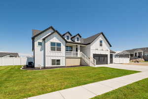 Modern farmhouse with board and batten siding, an attached garage, driveway, and a porch