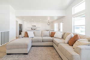 Living area with light wood finished floors, a chandelier, and recessed lighting
