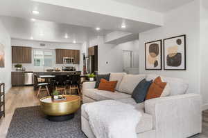 Living room with light wood-type flooring and recessed lighting