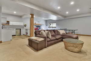 Living room with light colored carpet, recessed lighting, and baseboards