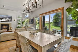 Dining area featuring light wood-style flooring, a fireplace, and a textured ceiling