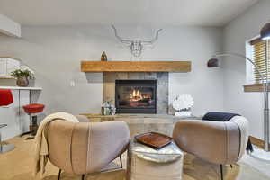 Living room with carpet, a tiled fireplace, and a textured ceiling