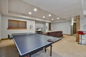 Game room featuring light carpet, baseboards, recessed lighting, and a raised ceiling