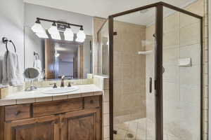 Full bathroom with vanity and a shower stall