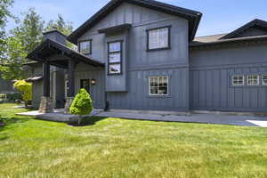 View of front of house with board and batten siding and a front lawn