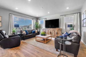 Living area featuring laminate floors and recessed lighting