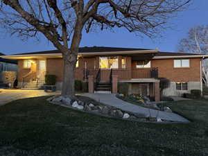 Single story home with brick siding and a front yard
