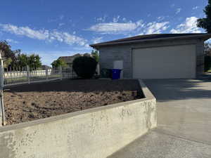 View of property exterior with a garage and driveway