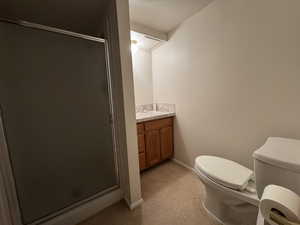 Bathroom with toilet, vanity, a shower stall, and baseboards