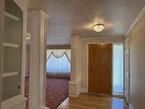 Entrance foyer with wood finished floors, a textured ceiling, and plenty of natural light